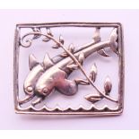 A silver square brooch with two dolphins. 3.5 x 3 cm.