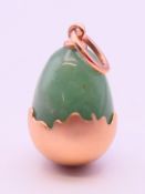 A 14 ct gold and jade egg pendant bearing Russian marks. 2 cm high.