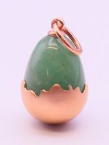 A 14 ct gold and jade egg pendant bearing Russian marks. 2 cm high.