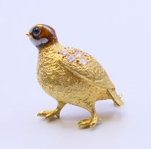A gold and enamel partridge form brooch set with diamonds and sapphires. 2.5 cm high. 9.7 grammes.