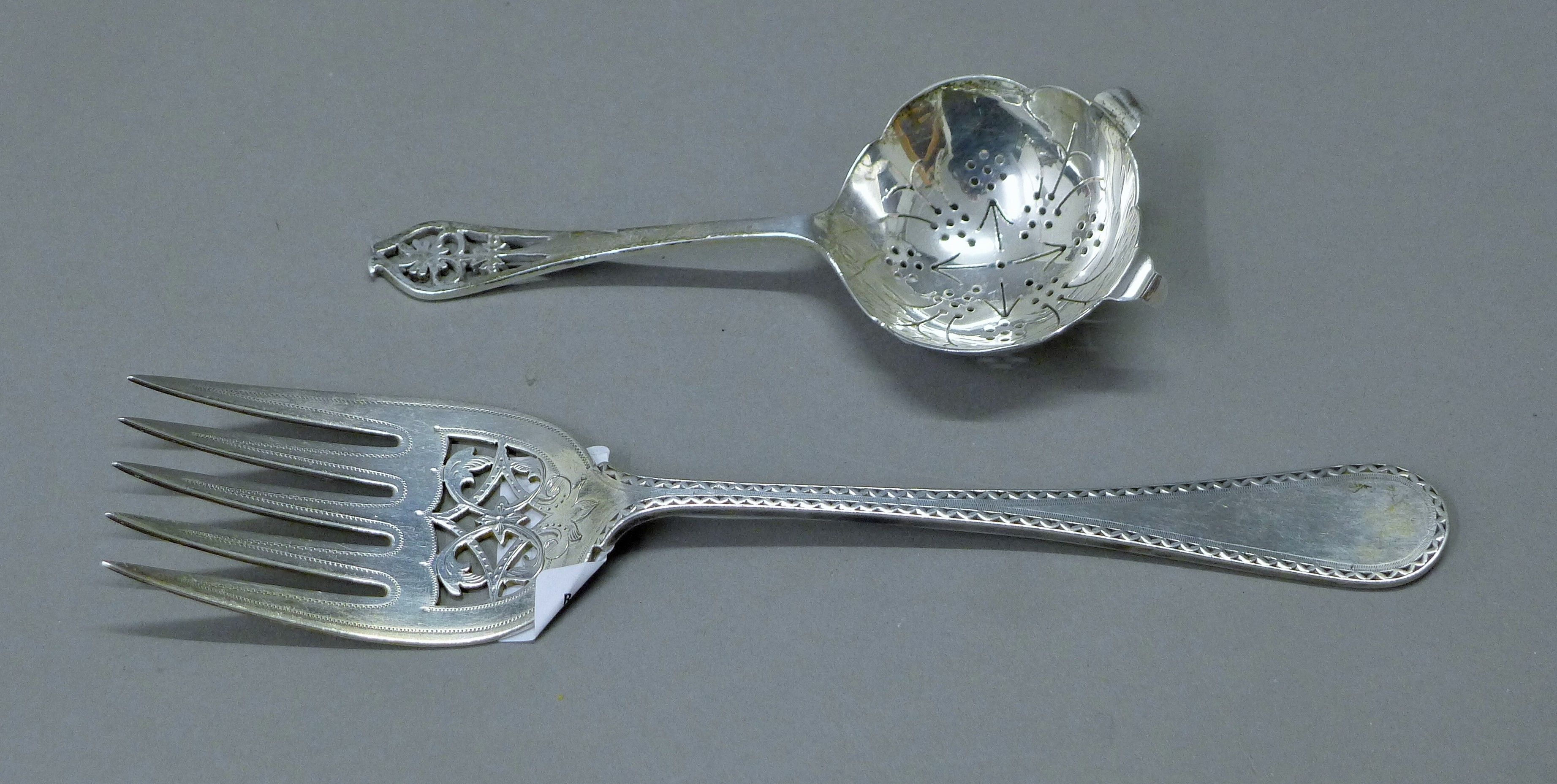 A silver serving fork and a silver sifter spoon. The former 24 cm long. 181.5 grammes.
