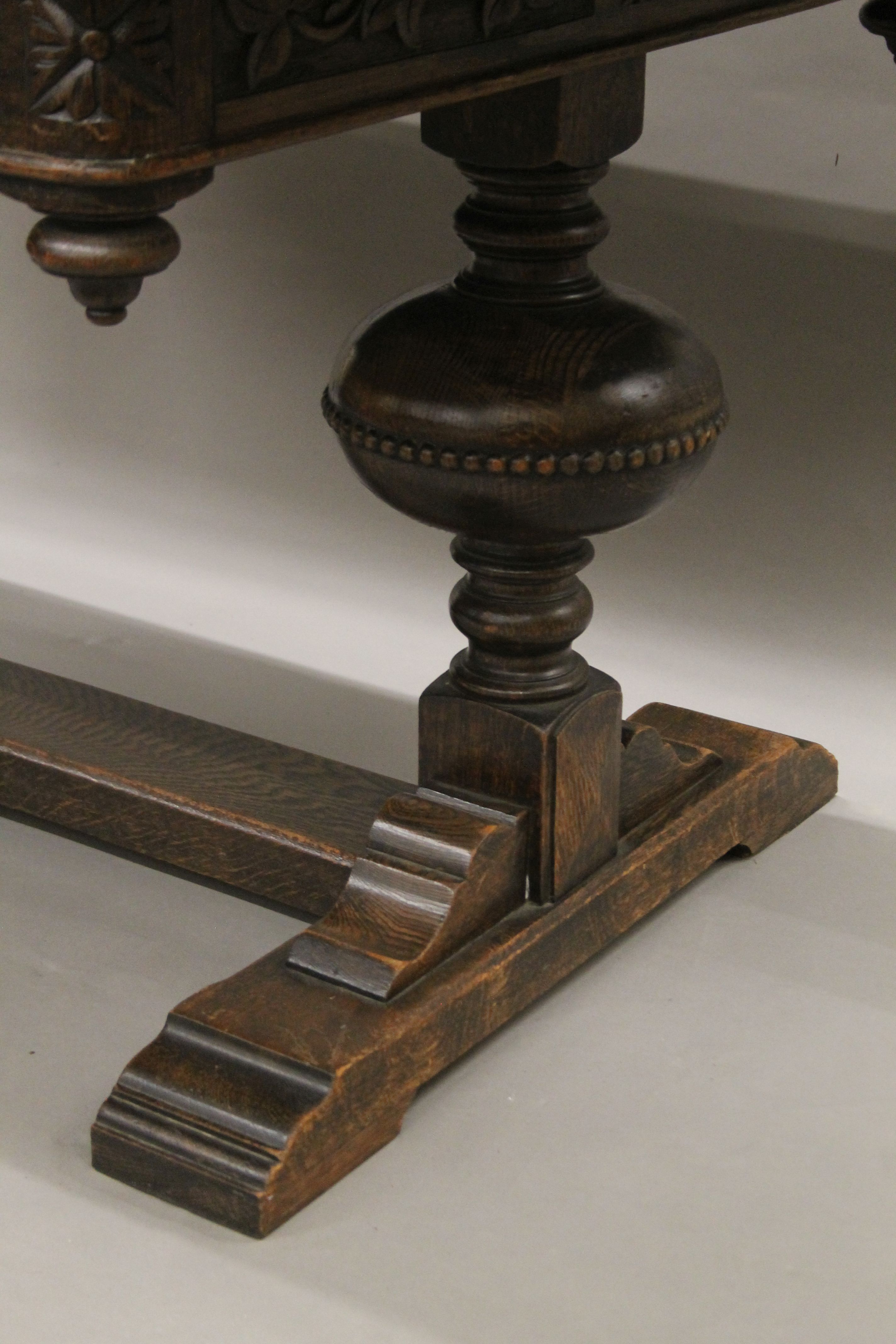 An early 20th century carved oak drawer leaf dining table. 193 cm long extended x 99 cm wide. - Image 5 of 6