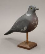 A vintage painted carved wooden pigeon decoy on stand. 32 cm long.