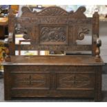 A Victorian carved oak settle. 106 cm wide.