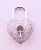 A silver cubic zirconia pendant in the form of a padlock heart with key escutcheon. 2.75 cm high.