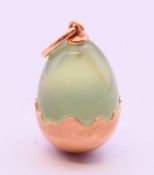 A 14 ct gold and jade pendant in the form of an egg. 2 cm high.