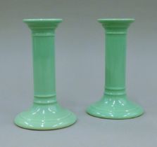 A pair of Doulton green ground candlesticks. 14 cm high.