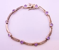 A silver bracelet set with heart shaped amethysts. 17 cm long.