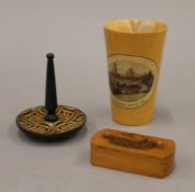 A Mauchline puzzle vesta, an Ely Cathedral beaker and a pin tray. The former 7 cm long.