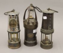 Three vintage miner's lamps. The largest 27 cm high.