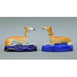 Two 19th century Staffordshire recumbent greyhound inkwells. The largest 15 cm long.