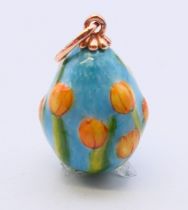 A 14 ct gold and enamel egg pendant decorated with tulips, bearing Russian marks. 2 cm high.