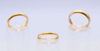 Three gold wedding bands, one 9 ct gold 3.3 grammes, and two 22 ct gold 4.2 grammes.