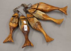 A quantity of carved wooden fish. Each approximately 23 cm long.