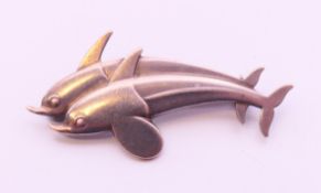 A Georg Jensen brooch in the form of two dolphins. 4 cm long.