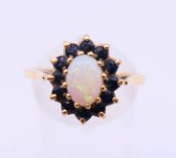 A 9 ct gold, opal and sapphire ring. Ring size S.