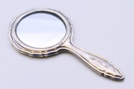 A silver small hand mirror. 12.5 cm high.