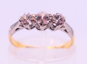 An 18 ct gold and platinum three stone diamond ring. Ring size K/L.
