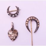 A horseshoe stick pin, a crescent shaped brooch and a heart pendant. Stick pin 6.5 cm high.