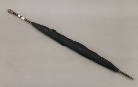 A late 19th/early 20th century umbrella, the handle mounted with a white metal dogs head.
