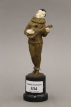 An Art Deco patinated bronze and ivory figure of a musician mounted on a marble plinth base.