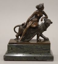 A 19th century bronze sculpture depicting a nude female astride a lioness mounted on a marble
