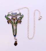 A silver Art Nouveau style pendant on a silver chain. Pendant 7.5 cm high, chain 44 cm long.
