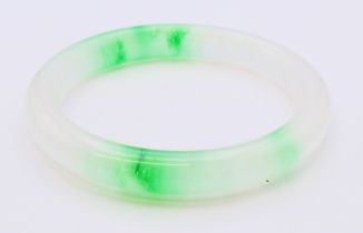 A two-tone jade bangle. 5.5 cm internal diameter.