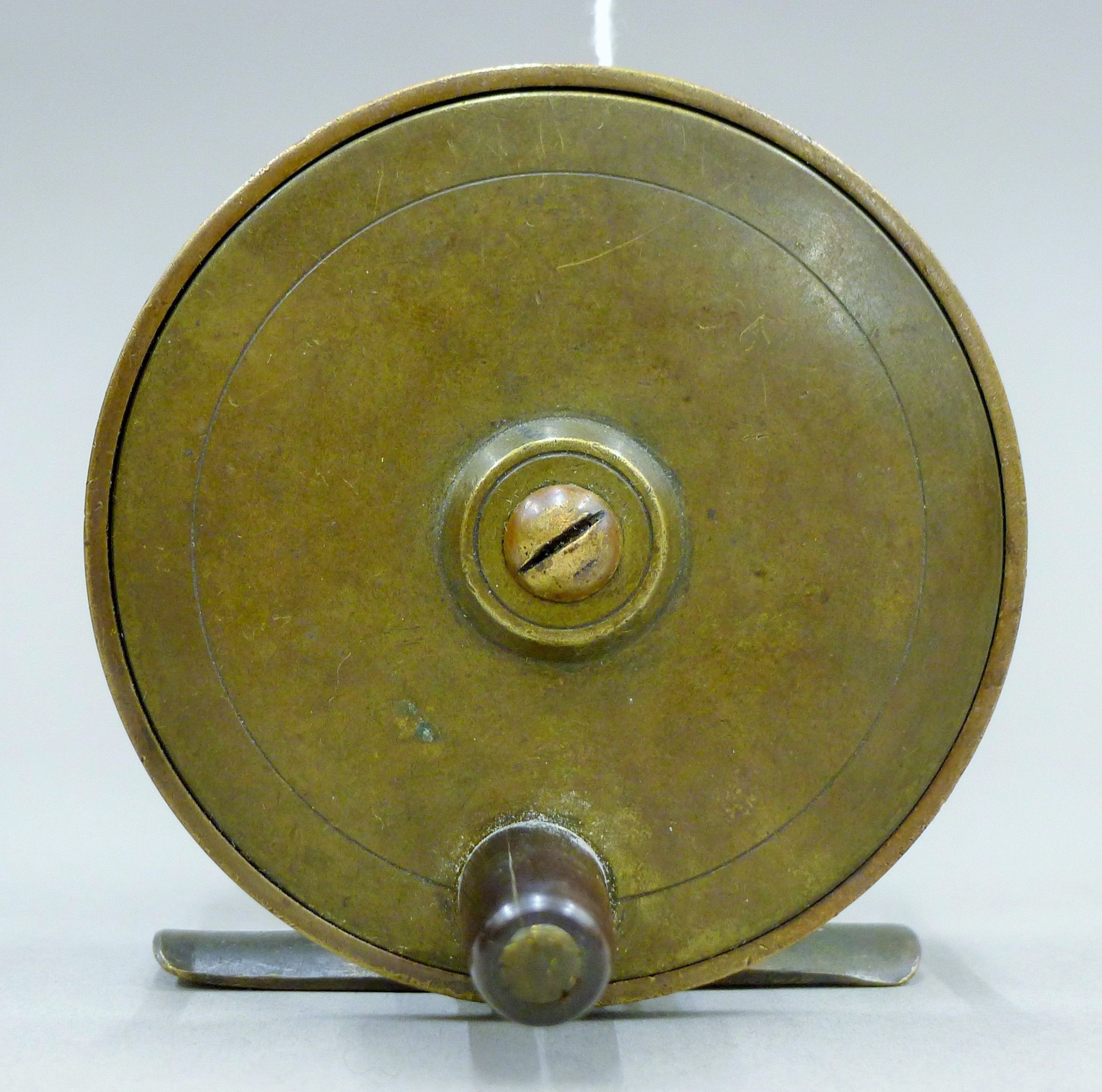 An Allcocks Brass platewind fly reel with early Allcock Stag logo on the foot. 8 cm diameter.