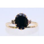 A 9 ct gold, diamond and sapphire three stone ring. Ring size K/L.