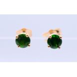 A pair of 14 k gold earrings set with green gemstones, possibly emeralds. 0.5 cm diameter.