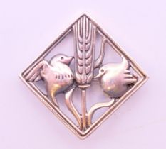 A silver brooch of square diagonal form enclosing a wheatsheaf flanked by two birds. 2.5 cm square.