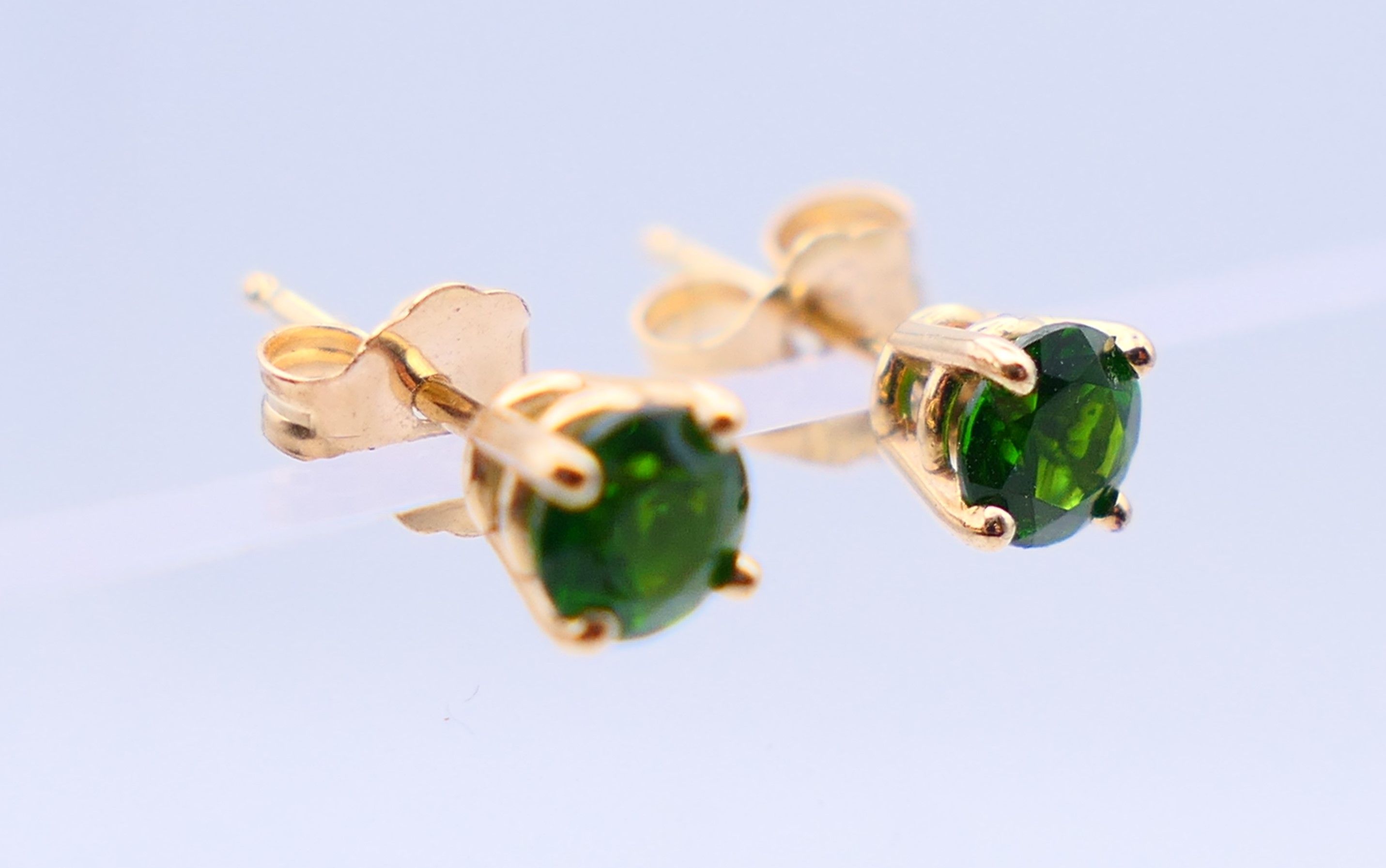 A pair of 14 k gold earrings set with green gemstones, possibly emeralds. 0.5 cm diameter. - Image 2 of 6