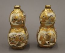 A pair of late 19th century Satsuma double gourd vases painted with figures within panels and