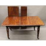 A 19th century mahogany two-leaf pull-out extending dining table.