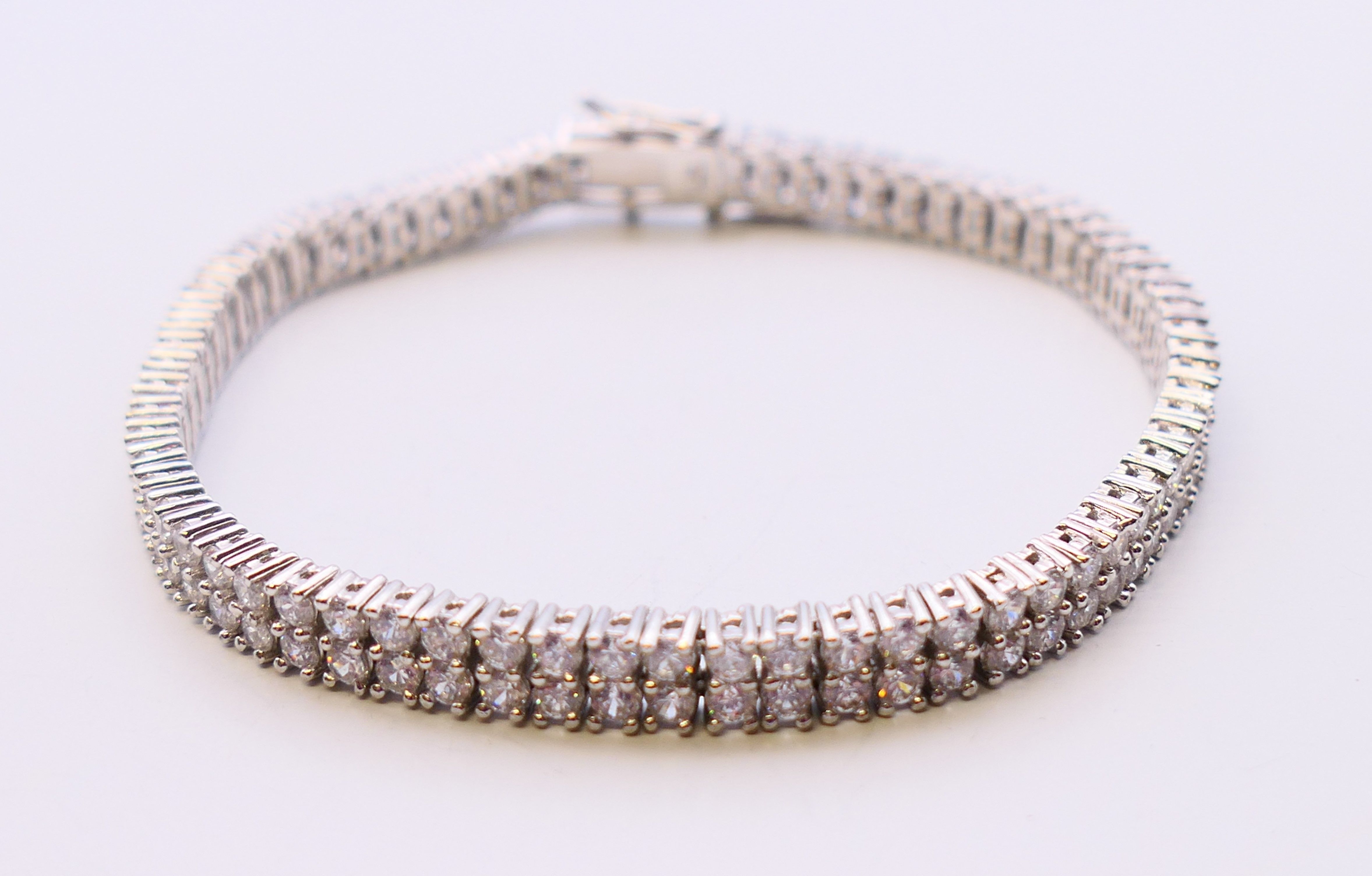 A silver cubic zirconia line bracelet. 20 cm long.