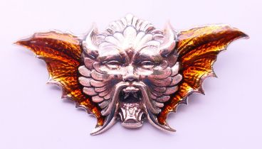A silver brooch in the form of a winged devil. 5.5 cm x 3 cm.