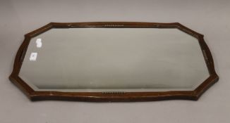 An early 20th century bevelled wall glass. 74 cm wide.