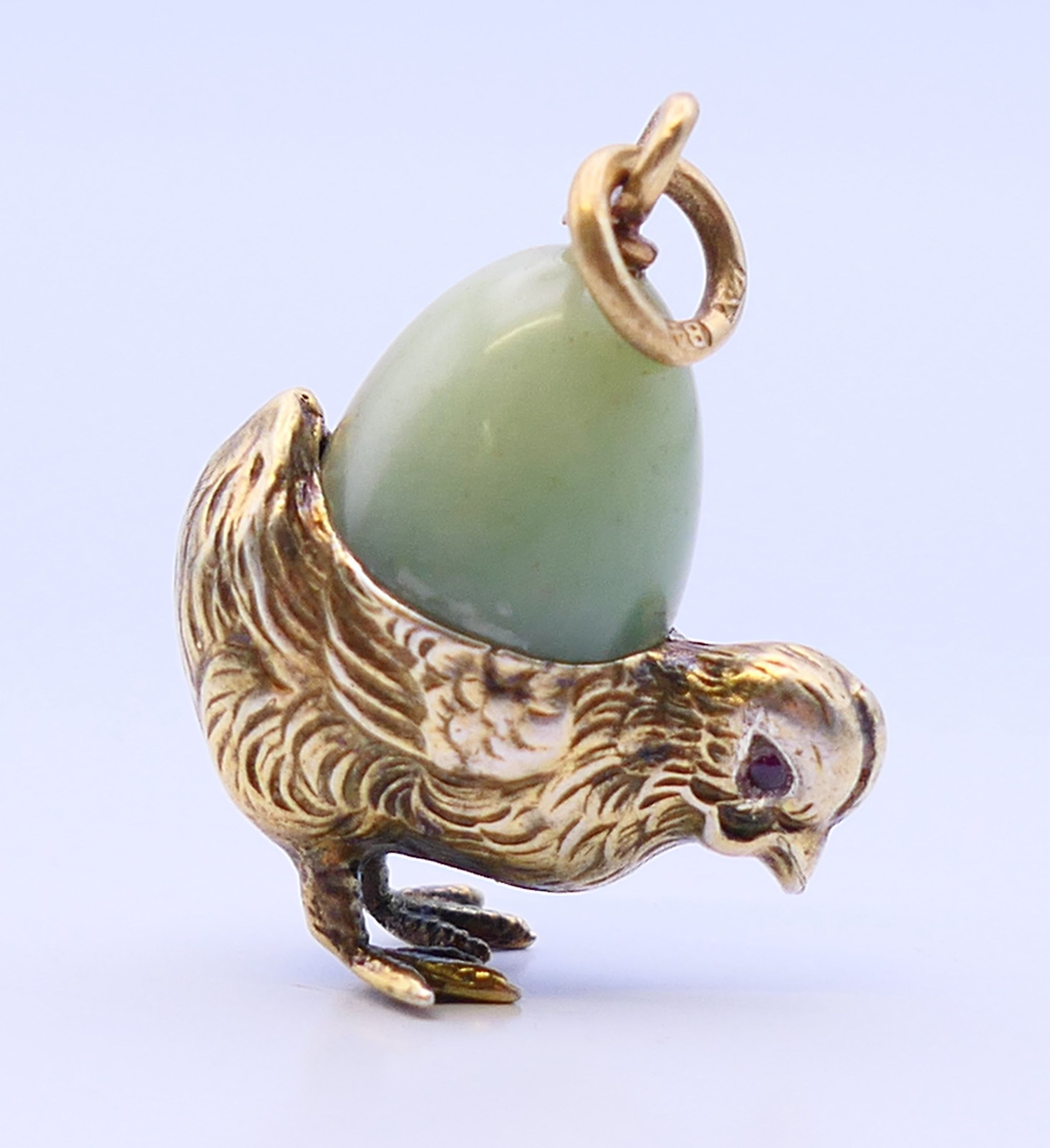 A silver and jade chick and egg pendant, bearing Russian marks. 2.5 cm high.