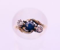An 18 ct gold, diamond and sapphire three-stone ring. Ring size I.