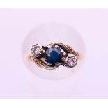 An 18 ct gold, diamond and sapphire three-stone ring. Ring size I.