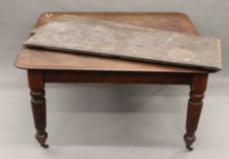 A 19th century mahogany pull-out extending dining table with two associated leaves.