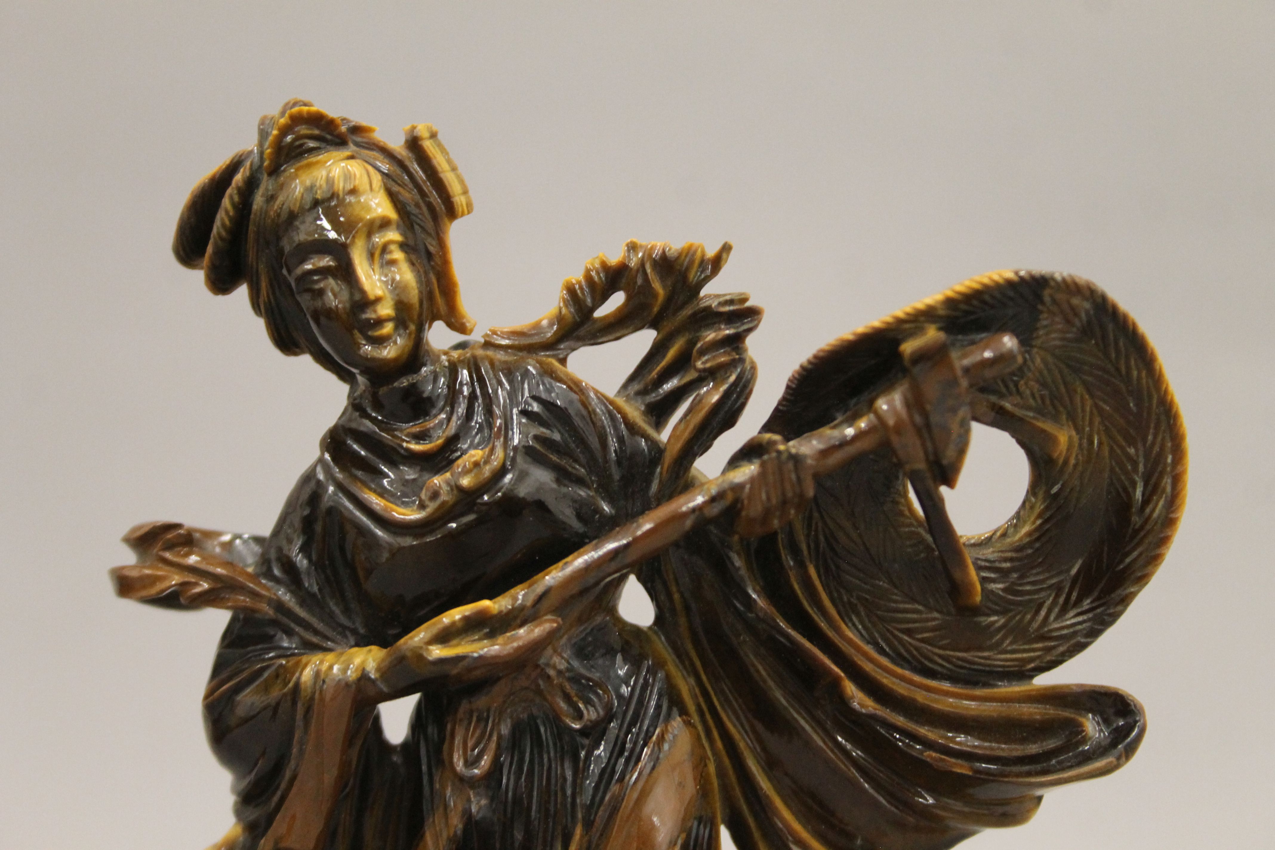 A Chinese tiger's eye hardstone carving of a maiden on a carved wood base. 18.5 cm high. - Image 3 of 5