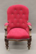 An button-upholstered Victorian mahogany open armchair. 62 cm wide.