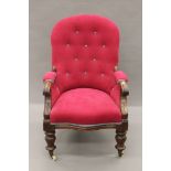An button-upholstered Victorian mahogany open armchair. 62 cm wide.