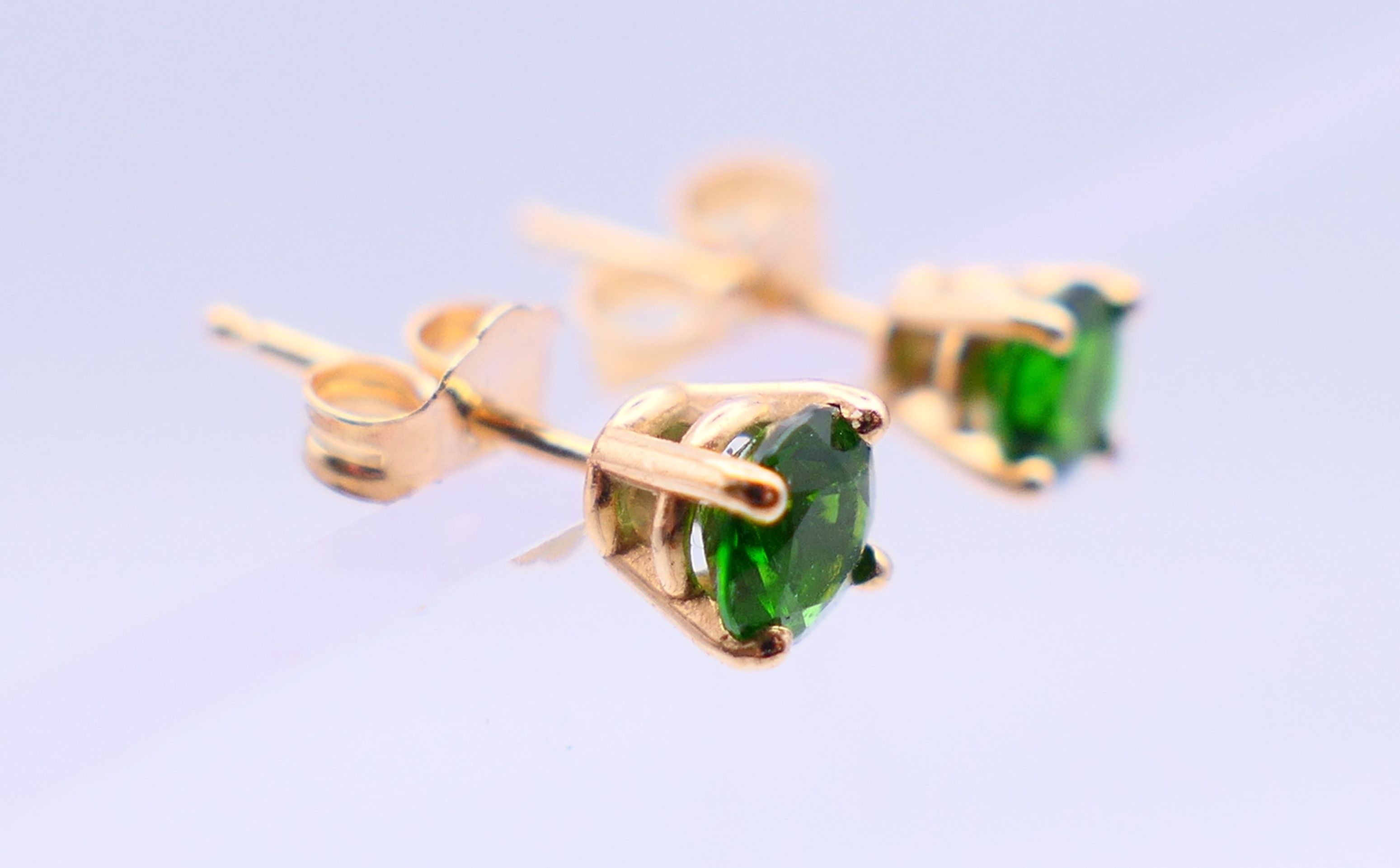 A pair of 14 k gold earrings set with green gemstones, possibly emeralds. 0.5 cm diameter. - Image 3 of 6