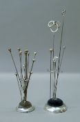 Four Charles Horner hat pins and a silver lovers knot hat pin in a silver plated hat pin stand;