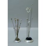 Four Charles Horner hat pins and a silver lovers knot hat pin in a silver plated hat pin stand;