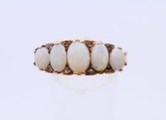 A 9 ct gold ring set with five opals. 4.1 grammes. Ring size U.
