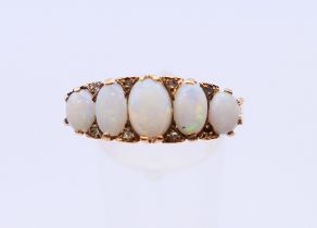 A 9 ct gold ring set with five opals. 4.1 grammes. Ring size U.